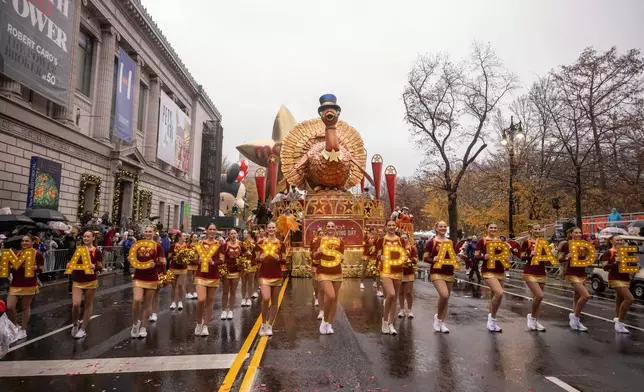 FILE - Parade performers lead the Tom Turkey float down Central Park West at the start of the Macy's Thanksgiving Day parade in New York on Nov. 28 2024. (AP Photo/Yuki Iwamura, File)