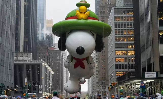 FILE - Handlers guide the Snoopy balloon down Sixth Avenue during the Macy's Thanksgiving Day Parade in New York on Nov. 28, 2024. (AP Photo/Julia Demaree Nikhinson, File)