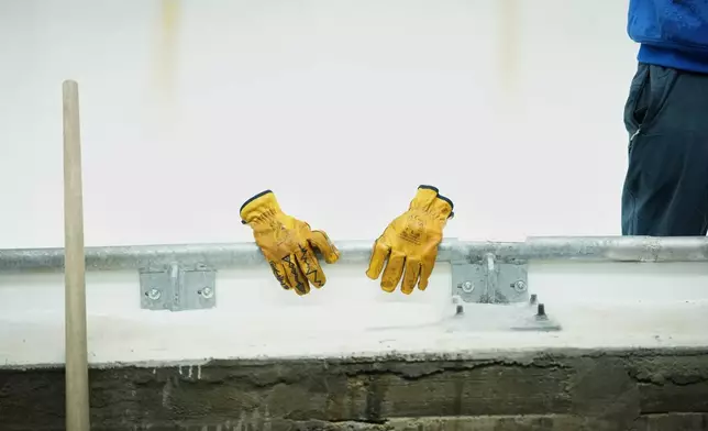 A worker's gloves and tool are lined up along the track ahead of a three-day skeleton and bobsled World Cup stage and Olympic test event in Cortina D'Ampezzo, Italy, Wednesday, Nov. 19, 2025. (AP Photo/Andrew Medichini)