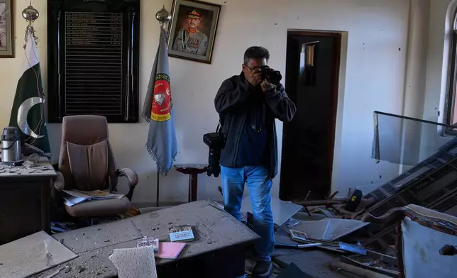 A photographer takes a picture of a damaged room of an army-run cadet college that was assaulted by militants on Monday, in Wana, a city in the northwestern Pakistani district South Waziristan bordering with Afghanistan, Thursday, Nov. 13, 2025. (AP Photo/Ahsan Shahzad)