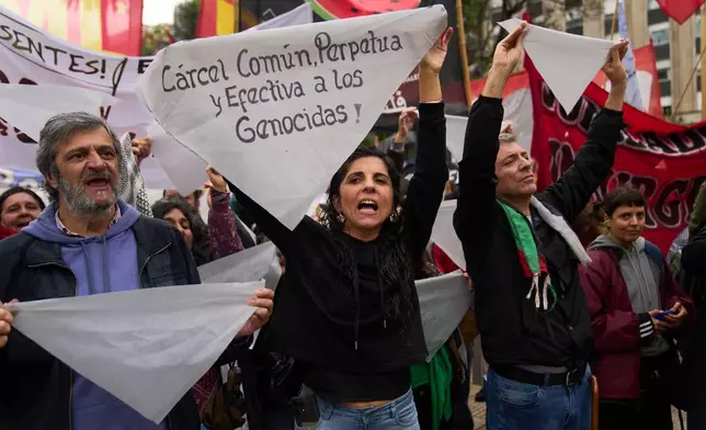 Protesters hold white headscarves during a countermarch to a demonstration organized by former servicemen accused of human rights violations during the last dictatorship, in Buenos Aires, Argentina, Saturday, Nov. 29, 2025. (AP Photo/Rodrigo Abd)