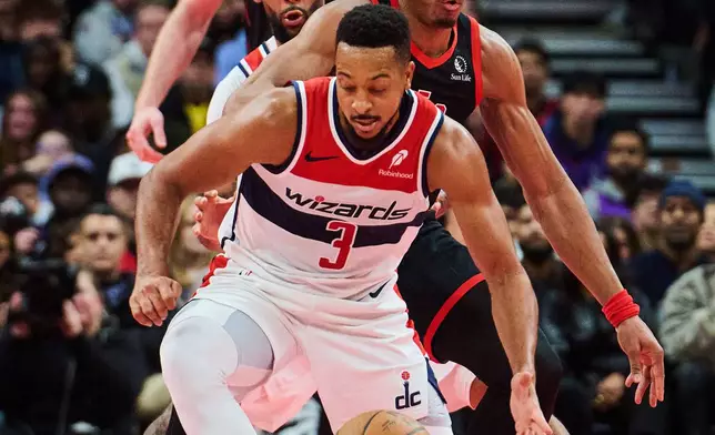 Washington Wizards' CJ McCollum (3) protects the ball from Toronto Raptors' Scottie Barnes (4) during first half NBA basketball action in Toronto, Friday, Nov. 21, 2025. (Sammy Kogan/The Canadian Press via AP)