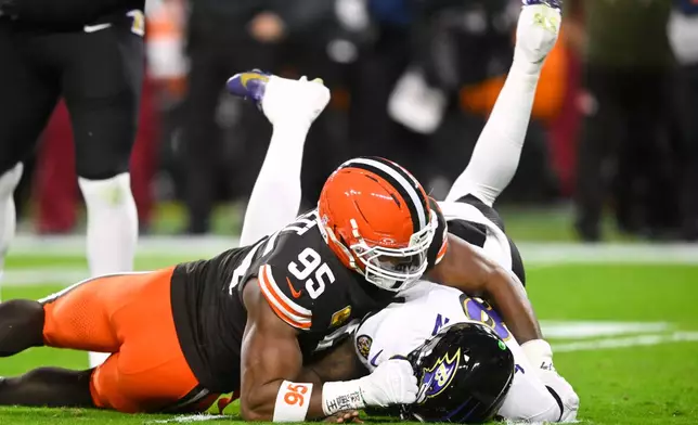 Cleveland Browns defensive end Myles Garrett (95) sacks Baltimore Ravens' Lamar Jackson (8) in the first half of an NFL football game in Cleveland, Sunday, Nov. 16, 2025. (AP Photo/David Richard)