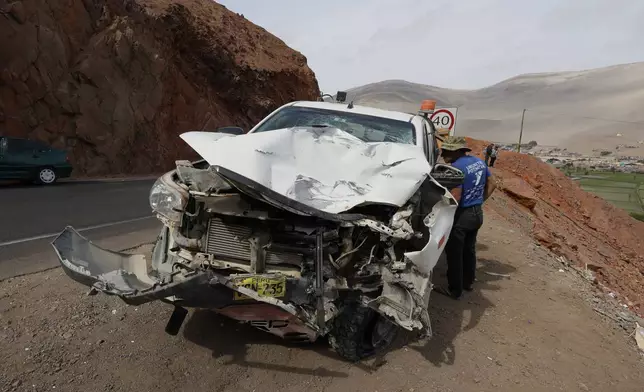 A man inspects a vehicle after its deadly crash with a passenger bus in Arequipa, Peru, Wednesday, Nov. 12, 2025. (AP Photo/ Kiara Tapia)