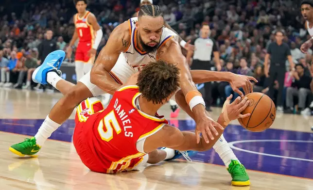 Phoenix Suns forward Dillon Brooks struggles for a loose ball with Atlanta Hawks guard Dyson Daniels (5) during the first half of an NBA basketball game in Phoenix, Sunday, Nov. 16, 2025. (AP Photo/Darryl Webb)