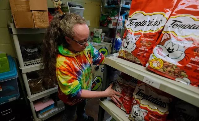 Jordan Robinson restocks a Pet food pantry, for families needing help to provide for their dogs and cats, at New Leash On Life animal shelter, Thursday, Nov. 6, 2025, in Lebanon, Tenn. (AP Photo/George Walker IV)