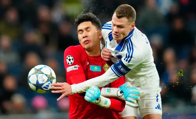 Copenhagen's Viktor Claesson, right, and Almaty's goalkeeper Temirlan Anarbekov, left, challenge for the ball during the Champions League opening phase soccer match between FC Copenhagen and Kairat Almaty in Copenhagen, Denmark, Wednesday, Nov. 26, 2025. (Ida Marie Odgaard/Ritzau Scanpix via AP)