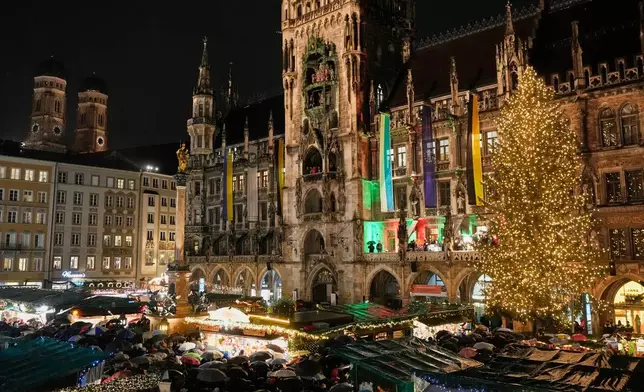 Lights illuminate the traditional Christmas Market that was opened at 'Marienplatz' square in Munich, Germany, Monday, Nov. 24, 2025. (AP Photo/Matthias Schrader)