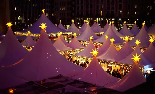 Lights illuminate the Christmas market at the Gendarmen Markt square in Berlin, Germany, Monday, Nov. 24, 2025. (AP Photo/Markus Schreiber)