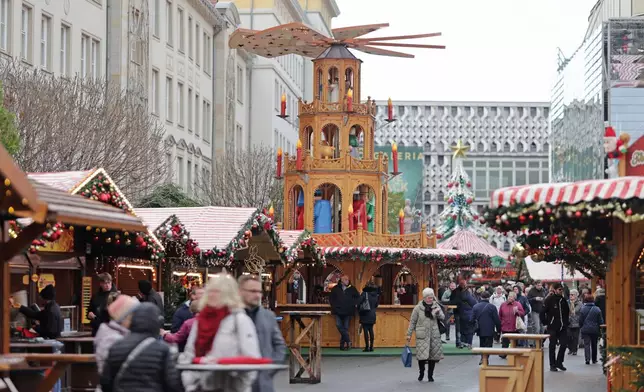 Visitors walk through the Magdeburg Christmas market, in Magdeburg, Germany, Thursday, Nov. 20, 2025. (Matthias Bein/dpa via AP)
