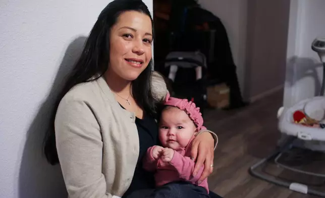 Yurany Dexter holds her 4-month-old daughter, who was recently hospitalized for botulism, at their home in Flagstaff, Ariz. on Wednesday, Nov. 12, 2025. (AP Photo/Cheyanne Mumphrey)