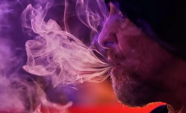 Miguel Laboy smokes cannabis, Oct. 3, 2025, in Brookline, Mass. (AP Photo/Robert F. Bukaty)