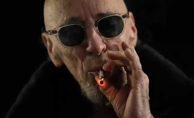 Miguel Laboy takes a hit of a joint Friday, Nov. 14, 2025, in Brookline, Mass. (AP Photo/Robert F. Bukaty)