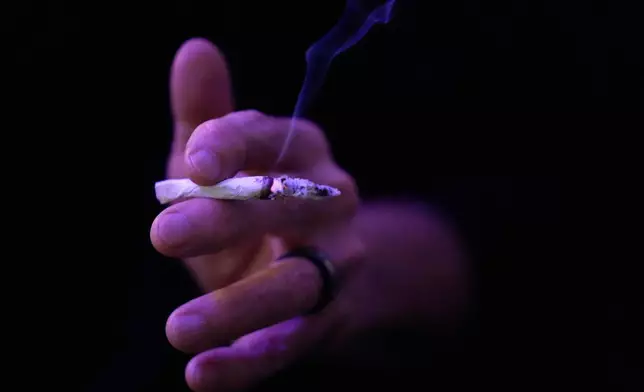 Miguel Laboy smokes a joint on Oct. 3, 2025, in Brookline, Mass. (AP Photo/Robert F. Bukaty)