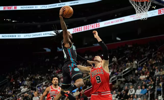 Detroit Pistons guard Daniss Jenkins, left, shoots against Chicago Bulls center Nikola Vucevic during the first half of an NBA basketball game, Wednesday, Nov. 12, 2025, in Detroit. (AP Photo/Ryan Sun)