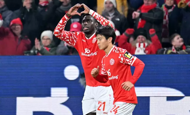 Mainz's Danny da Costa, left, celebrates with Sota Kawasaki after his goal during the German Bundesliga soccer match between FSV Mainz 05 and TSG 1899 Hoffenheim in Mainz, Germany, Friday, Nov. 21, 2025. (Torsten Silz/dpa via AP)