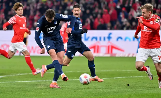 Hoffenheim's Fisnik Asllani, center, shoots on goal during the German Bundesliga soccer match between FSV Mainz 05 and TSG 1899 Hoffenheim in Mainz, Germany, Friday, Nov. 21, 2025. (Torsten Silz/dpa via AP)