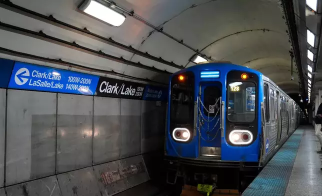 A train pulls into the Clark Street and Lake Street Blue Line stop where a man doused a woman in liquid and set her on fire on the train Monday night, Tuesday, Nov. 18, 2025, in Chicago. (AP Photo/Erin Hooley)