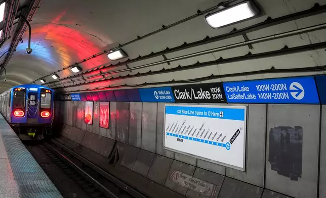 A train pulls away from the Clark Street and Lake Street Blue Line stop where a man doused a woman in liquid and set her on fire on the train Monday night, Tuesday, Nov. 18, 2025, in Chicago. (AP Photo/Erin Hooley)