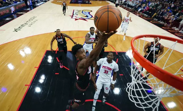 Philadelphia 76ers' VJ Edgecombe, left, goes up for a shot past Detroit Pistons' Javonte Green during the first half of an NBA basketball game Sunday, Nov. 9, 2025, in Philadelphia. (AP Photo/Matt Slocum)