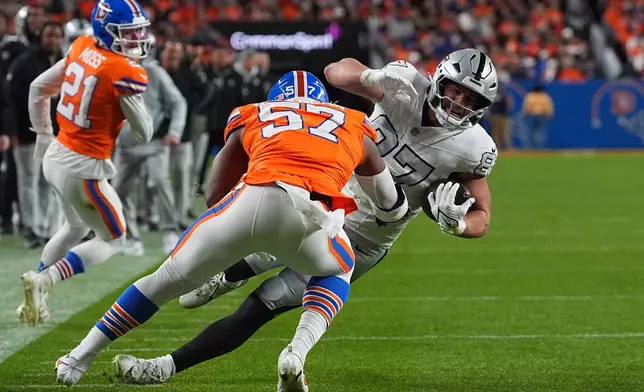Las Vegas Raiders tight end Michael Mayer (87) is stopped by Denver Broncos linebacker Dre Greenlaw (57) during the first half of an NFL football game Thursday, Nov. 6, 2025, in Denver. (AP Photo/David Zalubowski)