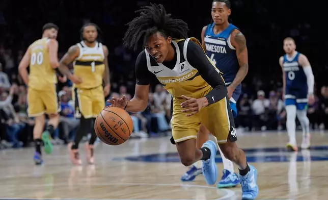 Washington Wizards guard Bub Carrington (7) tries to gain control of the ball during the first half of an NBA basketball game against the Minnesota Timberwolves, Wednesday, Nov. 19, 2025, in Minneapolis. (AP Photo/Abbie Parr)
