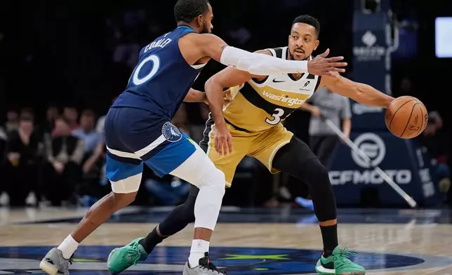 Minnesota Timberwolves forward Jaden McDaniels (3) handles the ball as Minnesota Timberwolves guard Mike Conley (10) defends during the second half of an NBA basketball game, Wednesday, Nov. 19, 2025, in Minneapolis. (AP Photo/Abbie Parr)