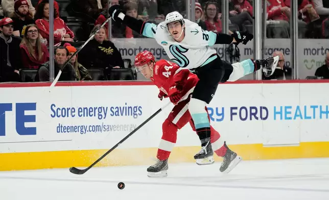 Seattle Kraken left wing Mason Marchment, right, collides with Detroit Red Wings defenseman Axel Sandin-Pellikka during the first period of an NHL hockey game Tuesday, Nov. 18, 2025, in Detroit. (AP Photo/Ryan Sun)