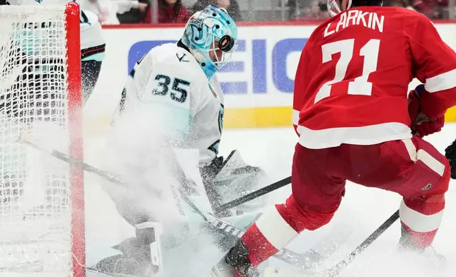 Detroit Red Wings center Dylan Larkin, right, is unable to score against Seattle Kraken goaltender Joey Daccord during the second period of an NHL hockey game, Tuesday, Nov. 18, 2025, in Detroit. (AP Photo/Ryan Sun)
