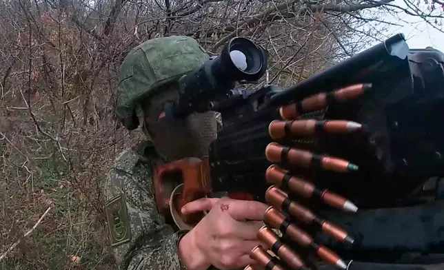 In this photo taken from a video provided by Russian Defense Ministry press service on Tuesday, Nov. 18, 2025, Russian serviceman fires in an undisclosed location in Ukraine. (Russian Defense Ministry Press Service via AP)