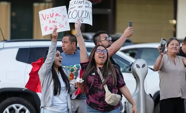 Protesters holds signs amidst the arrival of federal law enforcement, Monday, Nov. 17, 2025, in Charlotte, N.C. (AP Photo/Matt Kelley)