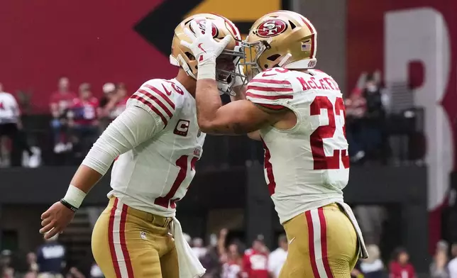 San Francisco 49ers quarterback Brock Purdy, left, and running back Christian McCaffrey celebrate after connecting on a touchdown pass against the Arizona Cardinals during the first half of an NFL football game in Glendale, Ariz., Sunday, Nov. 16, 2025. (AP Photo/Rick Scuteri)