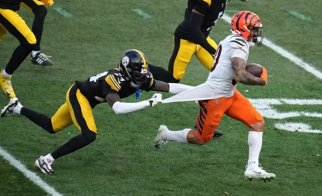 Pittsburgh Steelers cornerback Joey Porter Jr. (24) tries to tackle Cincinnati Bengals running back Chase Brown (30) during the second half of an NFL football game Sunday, Nov. 16, 2025, in Pittsburgh. (AP Photo/Gene J. Puskar)