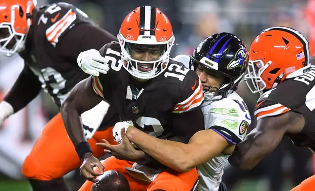 Cleveland Browns quarterback Shedeur Sanders (12) is sacked by Baltimore Ravens safety Kyle Hamilton (14) in the second half of an NFL football game in Cleveland, Sunday, Nov. 16, 2025. (AP Photo/David Richard)