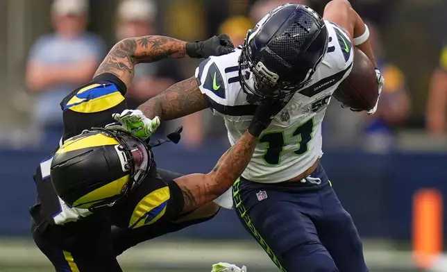 Seattle Seahawks wide receiver Jaxon Smith-Njigba, right, fends off Los Angeles Rams cornerback Cobie Durant during the first half of an NFL football game Sunday, Nov. 16, 2025, in Inglewood, Calif. (AP Photo/Gregory Bull)
