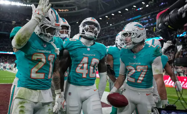 Miami Dolphins safety Ashtyn Davis (21), linebacker Willie Gay Jr. (40) and cornerback Ethan Bonner (27) react after regaining possession during the second half of an NFL football game between the Washington Commanders and the Miami Dolphins in Madrid, Spain, Sunday, Nov. 16, 2025. (AP Photo/Bernat Armangue)