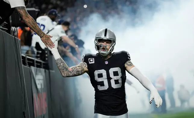 Las Vegas Raiders defensive end Maxx Crosby gets a high-five from a fan prior to an NFL football game against the Dallas Cowboys Monday, Nov. 17, 2025, in Las Vegas. (AP Photo/John Locher)