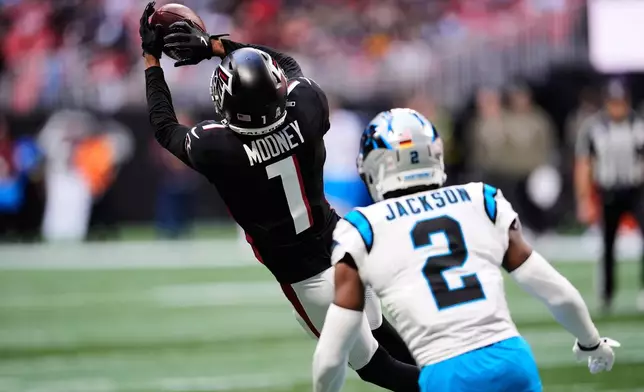 Atlanta Falcons running back Bijan Robinson (7) pulls in a pass in front of Carolina Panthers cornerback Mike Jackson (2) in the first half of an NFL football game, Sunday, Nov. 16, 2025, in Atlanta. (AP Photo/Mike Stewart)