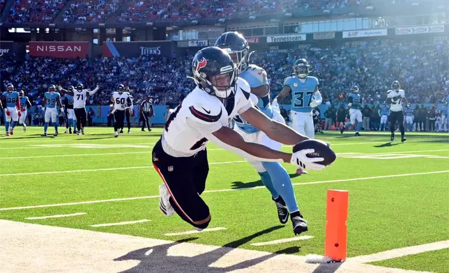 Houston Texans wide receiver Jayden Higgins, front, is pushed out of bounds short of the goal line by Tennessee Titans cornerback Darrell Baker Jr. during the second half of an NFL football game on Sunday, Nov. 16, 2025, in Nashville, Tenn. (AP Photo/John Amis)