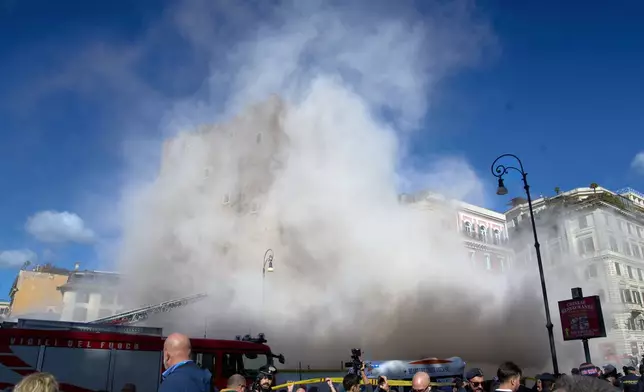 The medieval tower Torre dei Conti near the Roman Forum is engulfed by a cloud of debris from a second collapse after it had partially collapsed during renovation works, in Rome, Italy, Monday, Nov. 3, 2025. (AP Photo/Domenico Stinellis)