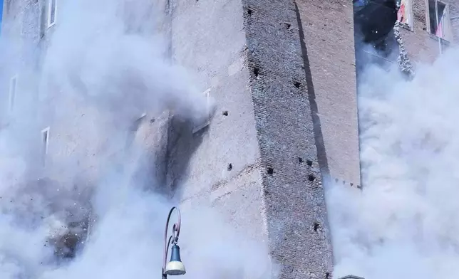 Firefighters work to rescue a construction worker from under the debris of the partially collapsed medieval Torre de Conti, meters away from the Colosseum in Rome, Monday, Nov. 3, 2025. (AP Photo/Domenico Stinellis)