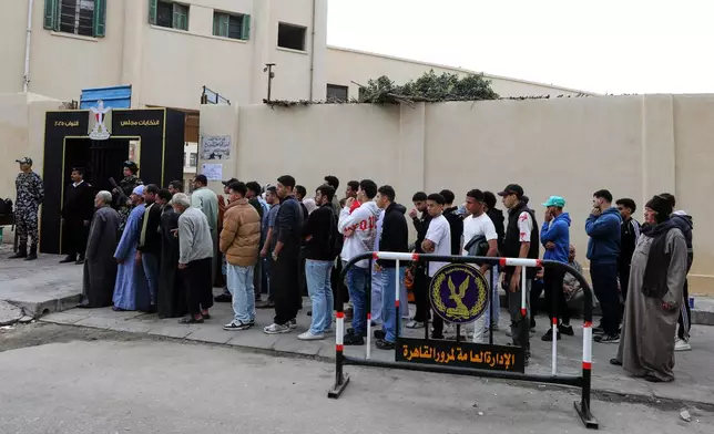 Egyptians line up as they wait for their turn to cast their ballots during the second phase of parliamentary elections in Cairo, Egypt, Monday, Nov. 24, 2025. (AP Photo/Khaled Elfiqi)
