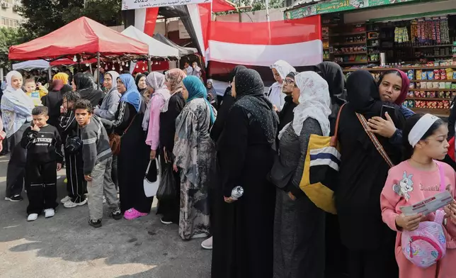 Voters line up at a polling station to vote during the first round of parliamentary elections in Giza, Egypt, Monday, Nov. 10, 2025. (AP Photo/Khaled Elfiqi