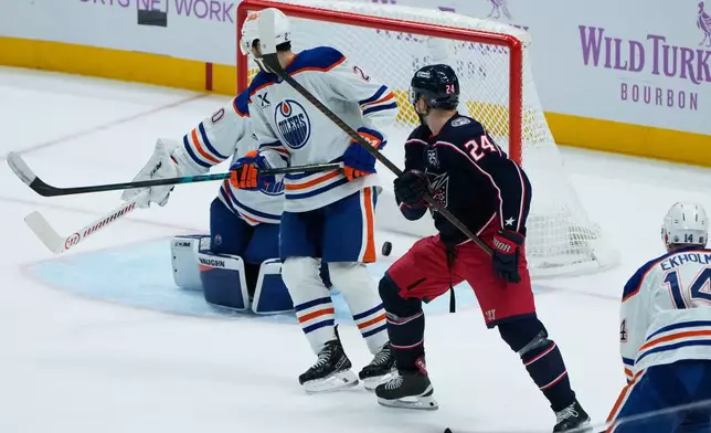 Columbus Blue Jackets right wing Mathieu Olivier (24) and Edmonton Oilers center Curtis Lazar (20) watch Olivier's goal in the first period of an NHL hockey game in Columbus, Thursday, Nov. 13, 2025. (AP Photo/Sue Ogrocki)
