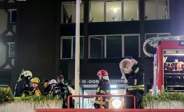 Firefighters stand guard in front of a nursing home after a fire in Tuzla, Bosnia, Tuesday, Nov. 4, 2025. (AP Photo)