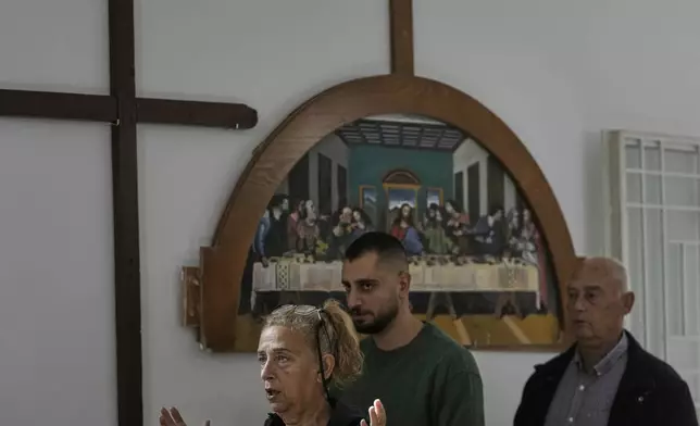 Worshippers attend Sunday Mass inside a room usually used as a residence for visiting bishops next to St. George Melkite Catholic Church, which was destroyed in an Israeli airstrike, in the town of Dardghaya, southern Lebanon, Sunday, Nov. 16, 2025. (AP Photo/Hassan Ammar)