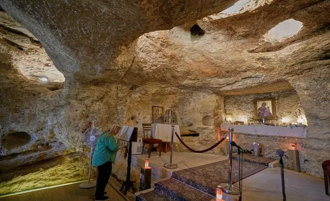 A woman prays inside the cave shrine of Our Lady of Waiting, Saydet al-Mantra, which local tradition identifies as the place where Mary waited for Jesus as he traveled through the nearby cities of Sidon and Tyre, where he answered a mother's plea to heal her daughter, at the southern village of Maghdouche, Lebanon, Sunday, Nov. 16, 2025. (AP Photo/Hassan Ammar)