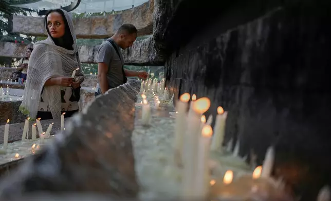 Pilgrims light candles at the Our Lady of Lebanon shrine in Harissa, east of Beirut, Lebanon, Sunday, Nov. 9, 2025. (AP Photo/Hassan Ammar)