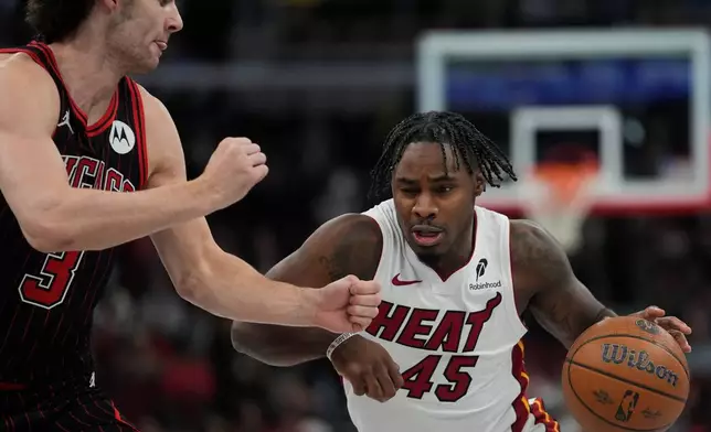 Chicago Bulls guard Josh Giddey (3), left, guards Miami Heat guard Davion Mitchell (45) during the first half of an NBA Cup basketball game Friday, Nov. 21, 2025, in Chicago. (AP Photo/Erin Hooley)