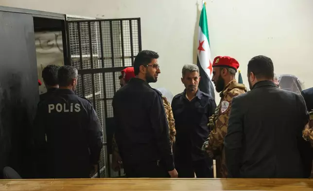 Security guards stand by a holding cell during Syria's first public trial related to deadly clashes in March along the country's coastal provinces, at the Palace of Justice in Aleppo, Syria, Tuesday, Nov. 18, 2025. (AP Photo/Ghaith Alsayed)